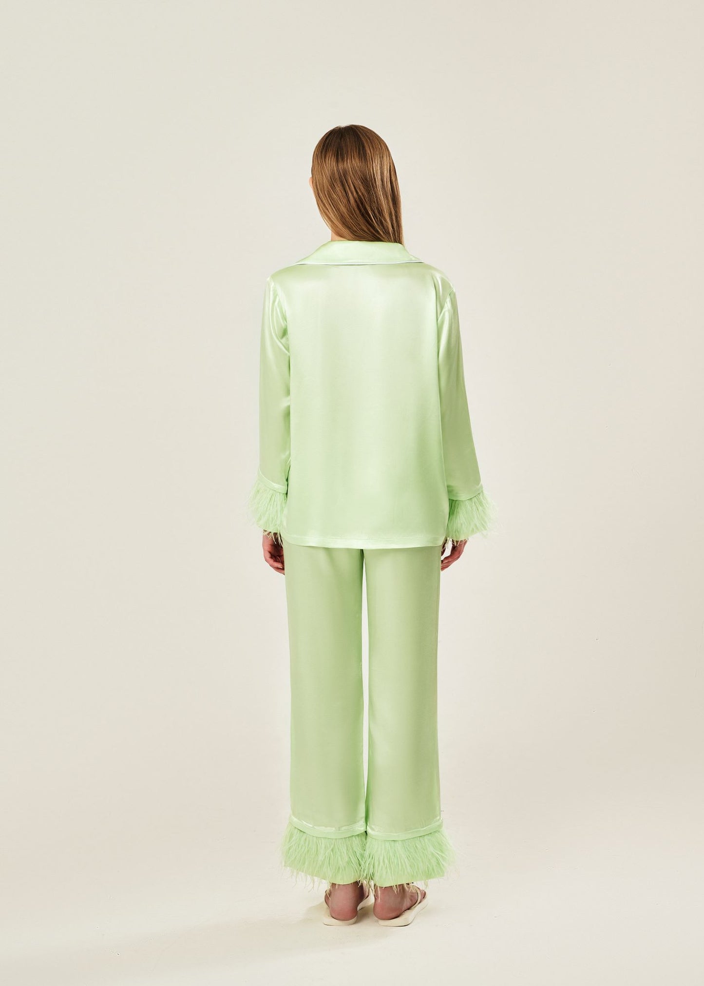 Back view of lime cream viscose mix rayon pajama set featuring a classic collar, floral buttons, and two front pockets. The detachable ostrich feather trim on the cuffs and pant hems adds a luxurious touch to the relaxed silhouette.