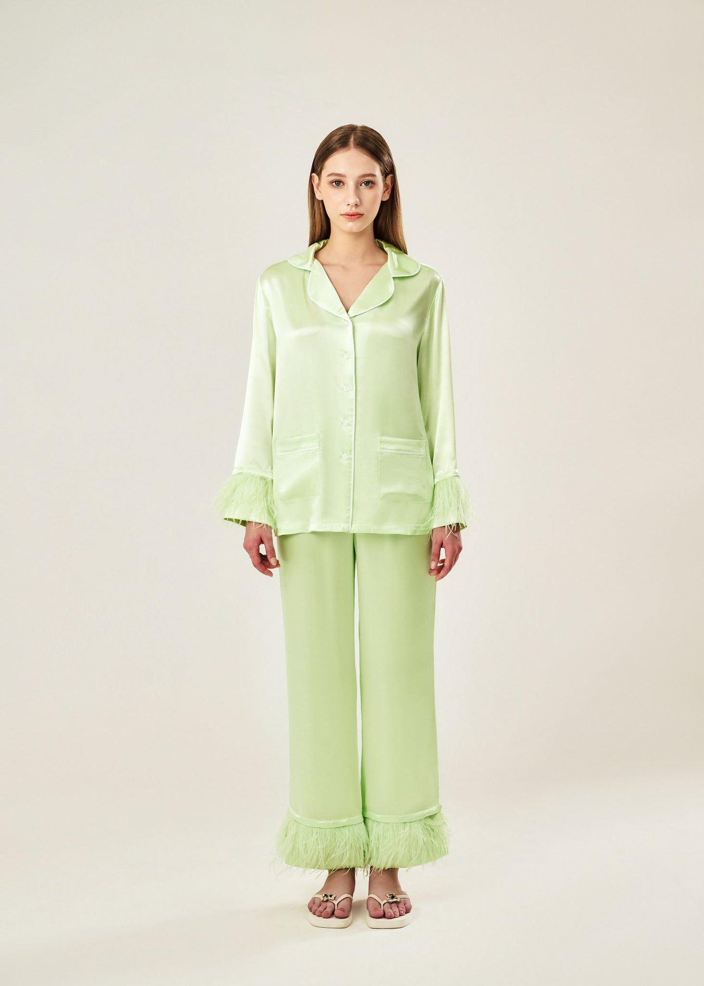 Front view of lime cream viscose mix rayon pajama set featuring a classic collar, floral buttons, and two front pockets. The detachable ostrich feather trim on the cuffs and pant hems adds a luxurious touch to the relaxed silhouette.