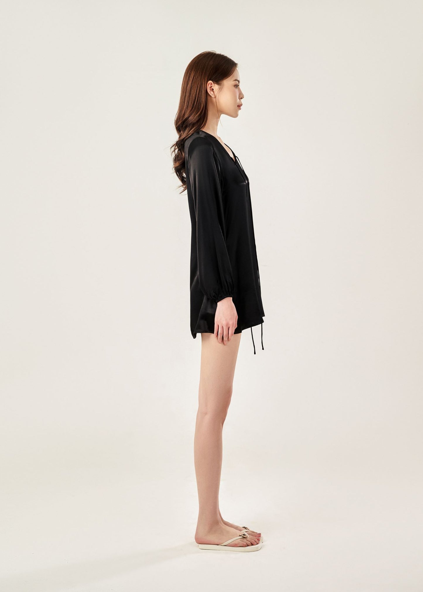 Side view of Cheries Apparel midi shirt dress in black, featuring puffed long sleeves, a V-neckline with double-needle stitching, and hidden pockets