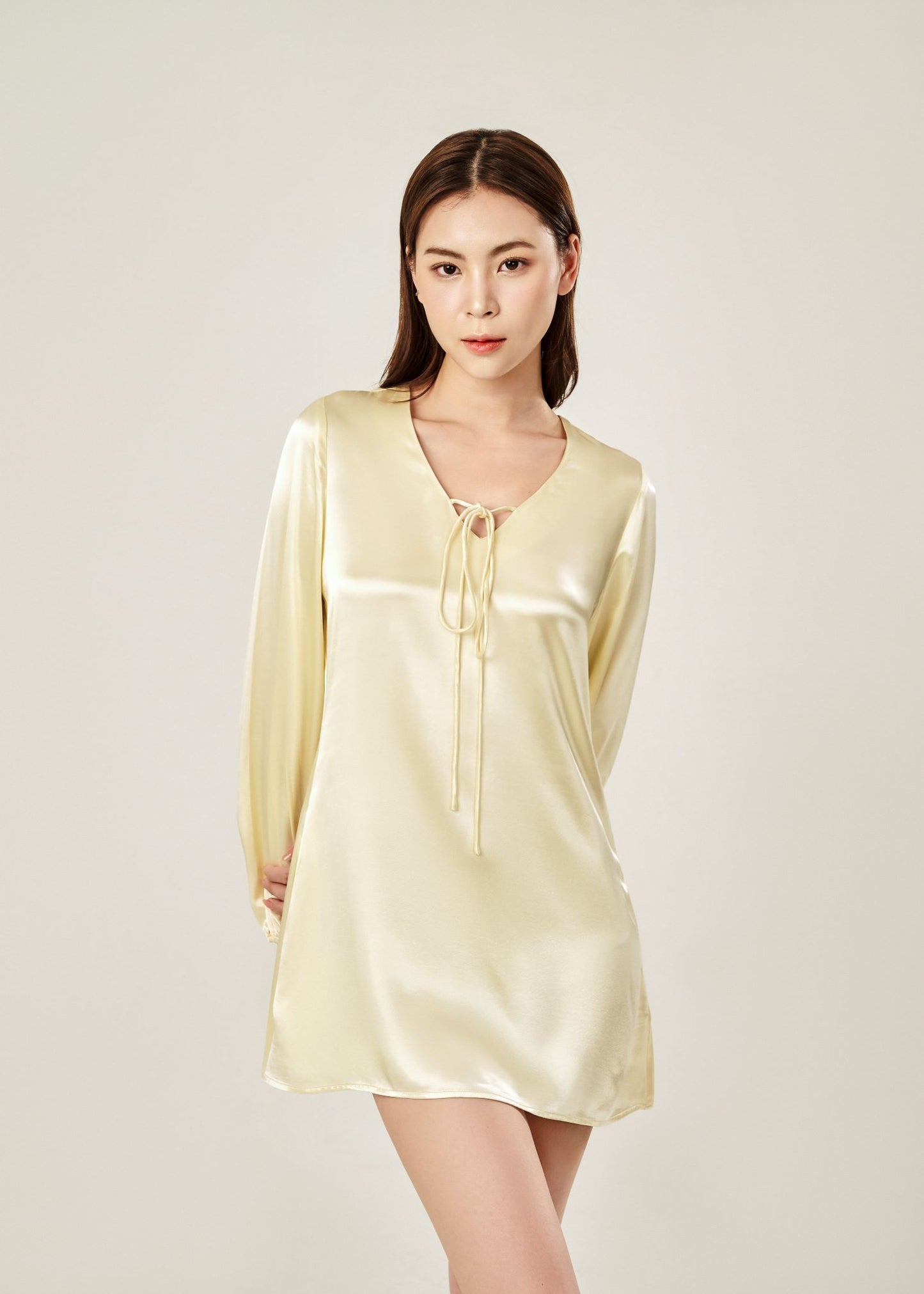 Detail view of Cheries Apparel midi shirt dress in beige, featuring puffed long sleeves, a V-neckline with double-needle stitching, and hidden pockets