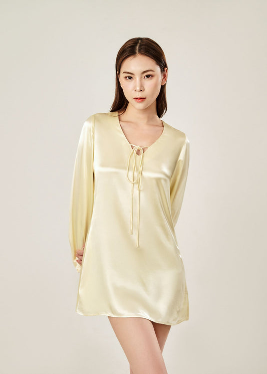 Detail view of Cheries Apparel midi shirt dress in beige, featuring puffed long sleeves, a V-neckline with double-needle stitching, and hidden pockets