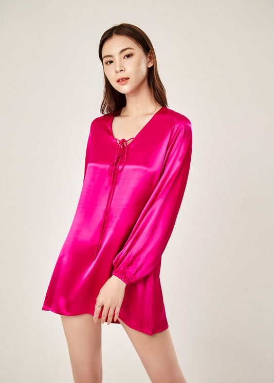 Detail view of Cheries Apparel midi shirt dress in raspberry pink, featuring puffed long sleeves, a V-neckline with double-needle stitching, and hidden pockets